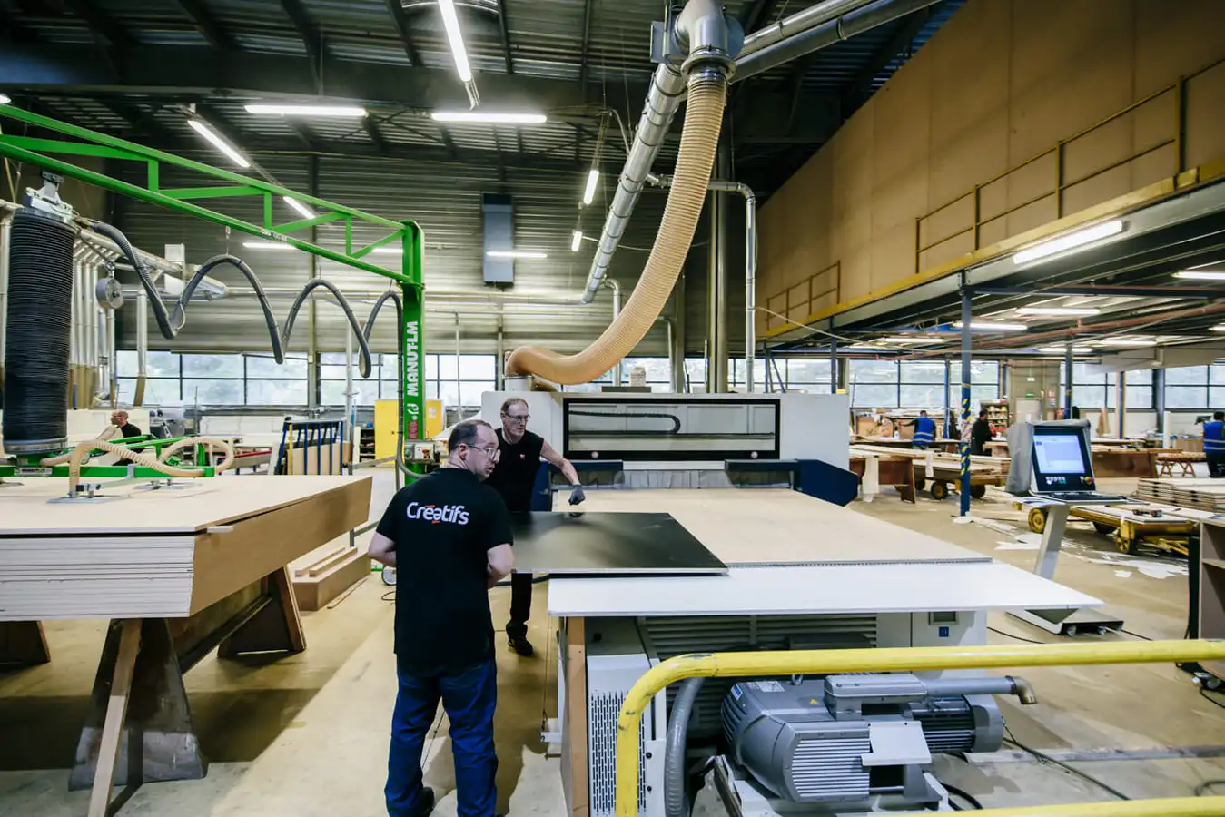 Deux hommes en train de faire de la menuiserie dans un atelier